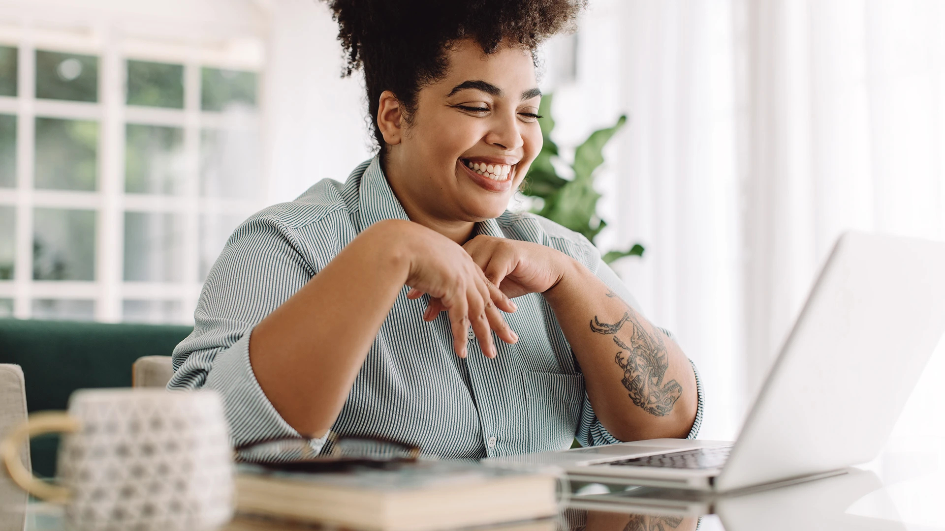 woman smilling while looking at laptop working from home on her scheduling software