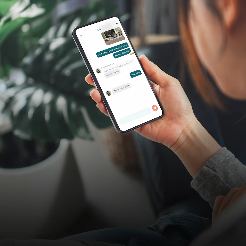 femme avec un cellulaire en main qui regarde la messagerie d'Agendrix