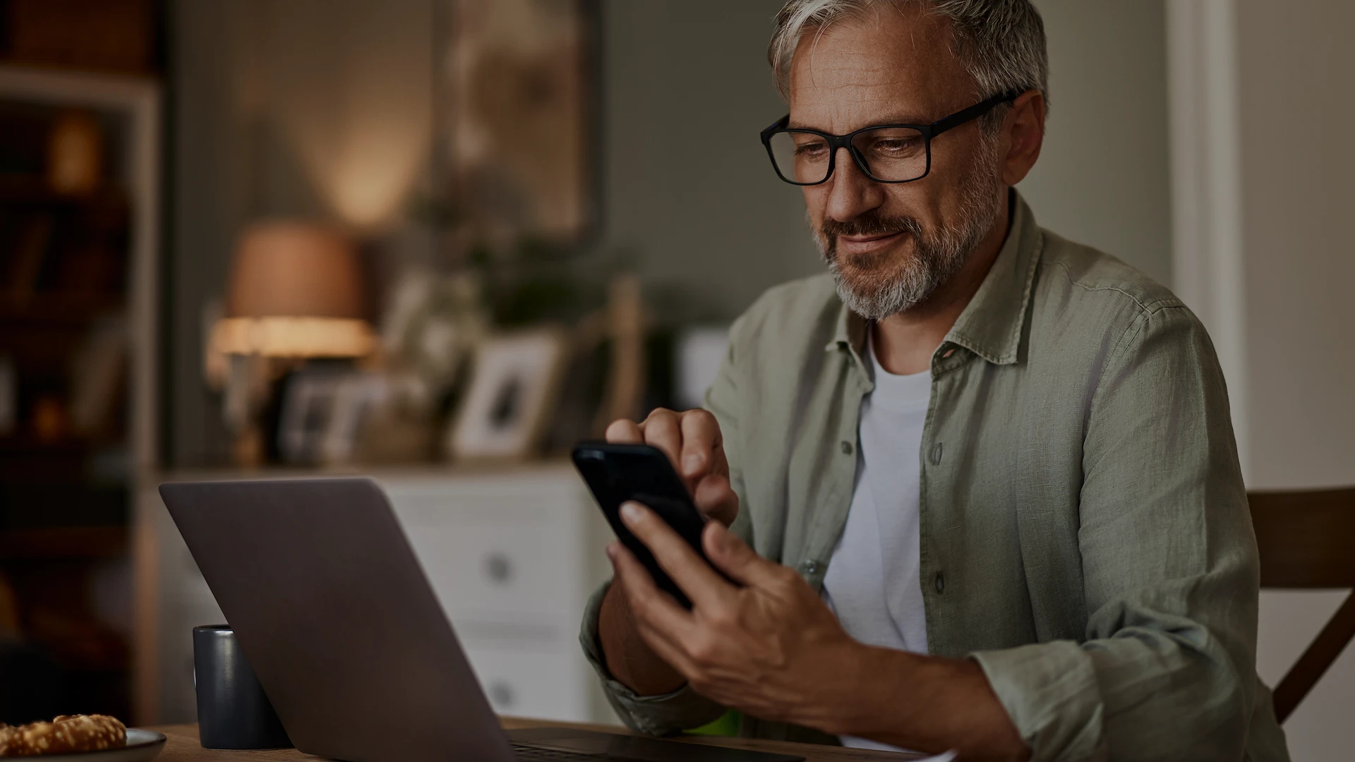 Man looking at the screen of a smartphone he's holding