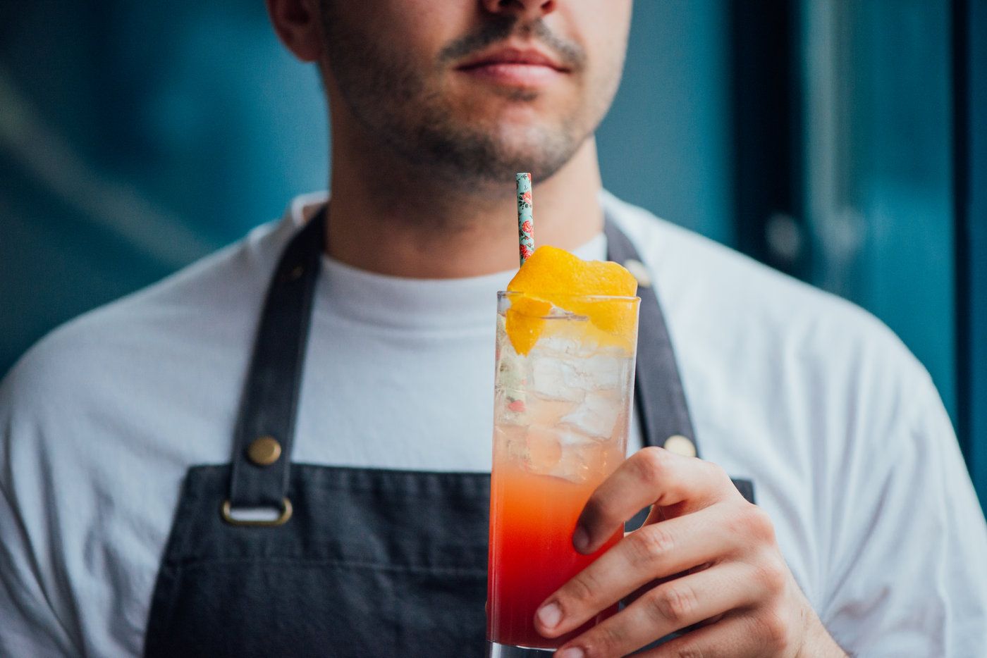 Barman tenant un verre signature du bar