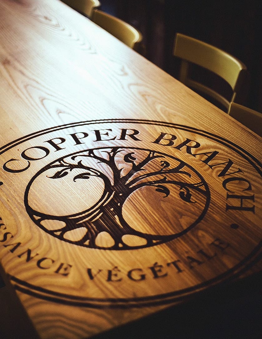 Logo de Cooper Branch gravé dans une table de bois