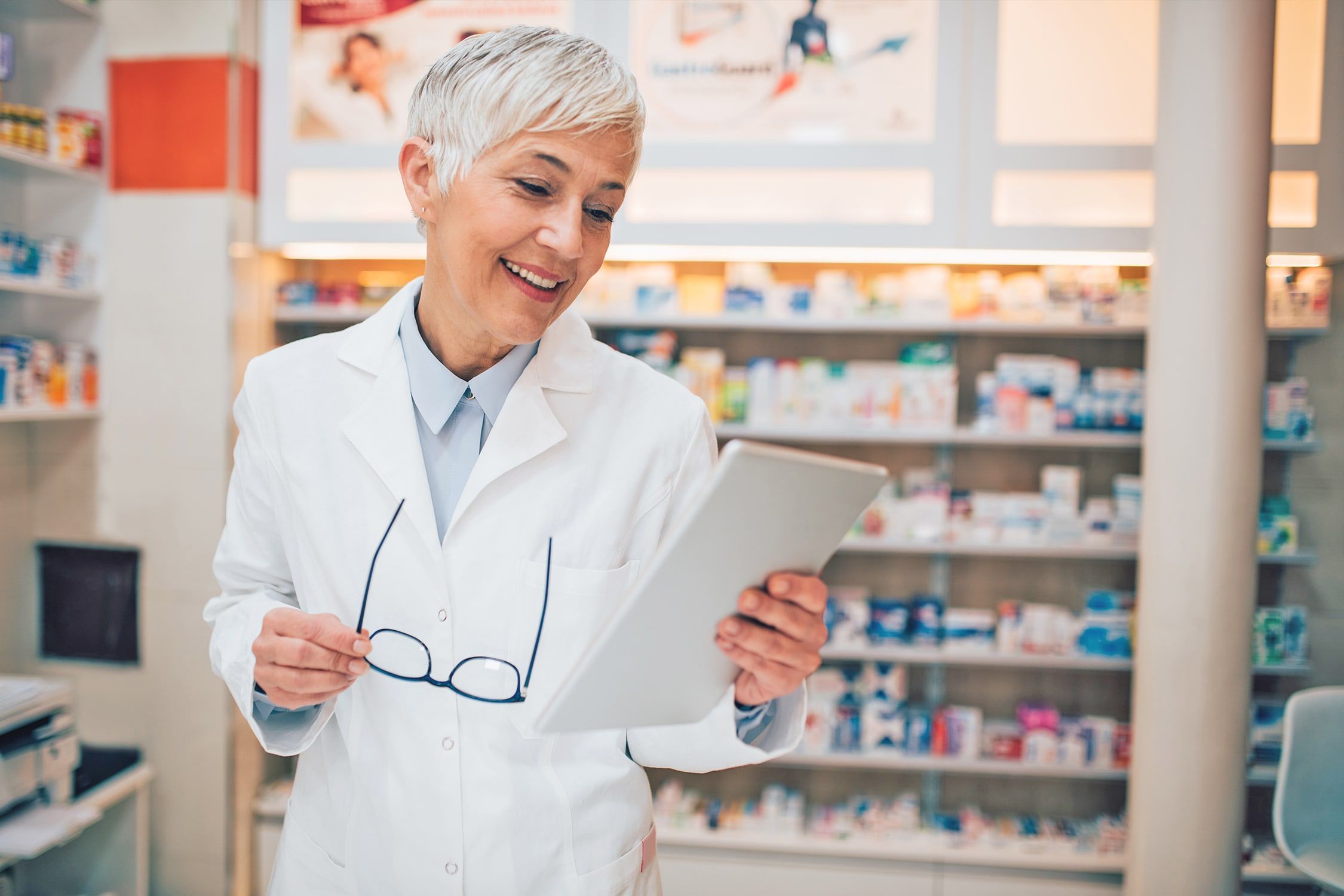 Pharmacienne sur le plancher tenant une tablette