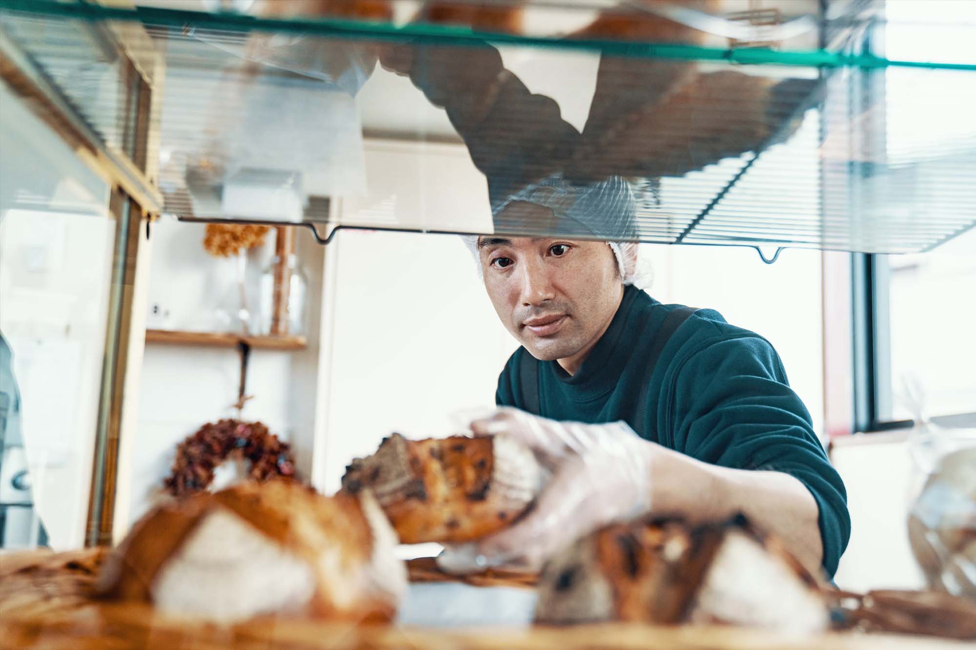 Pâtissier qui place une viennoiserie dans un présentoir