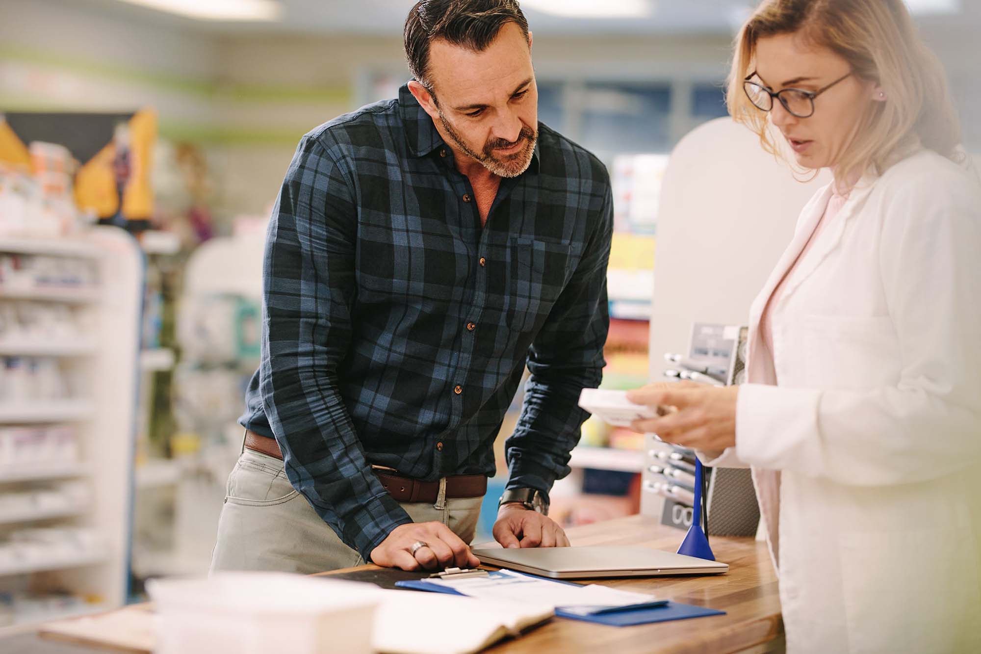 Homme recevant les informations d'un produit par une pharmacienne