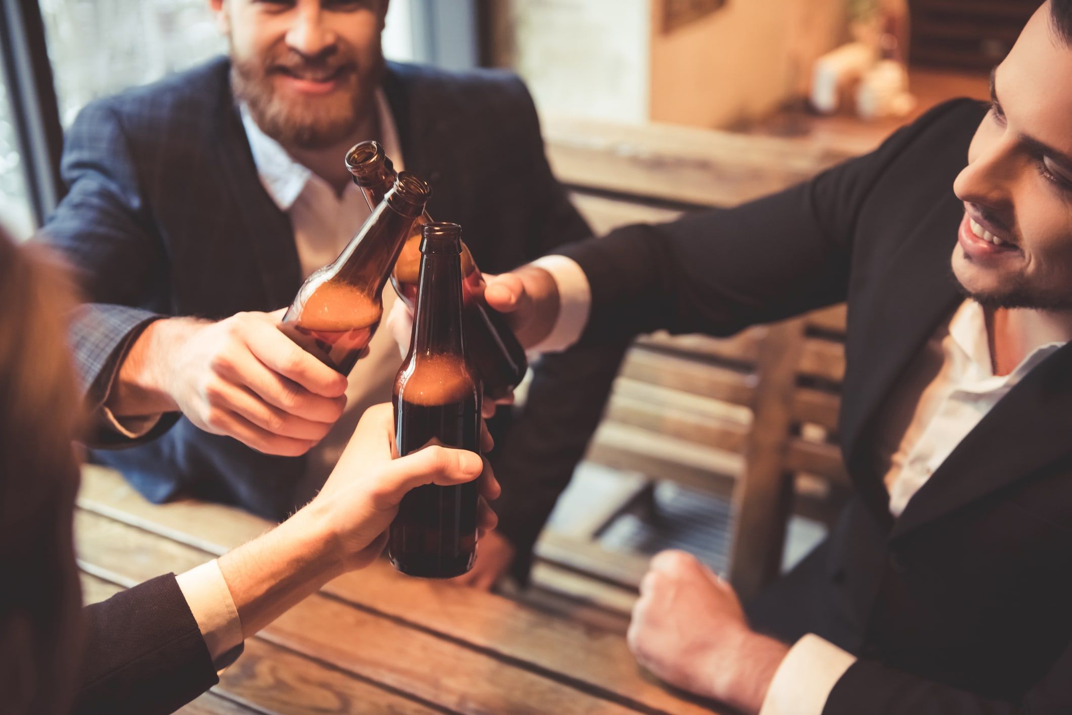 Trois amis qui partagent une bière à la fin d'une journée de travail pour se récompenser de leurs efforts