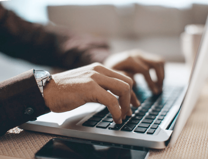 Hands typing on a keyboard representing how you can punch work hours with any computer