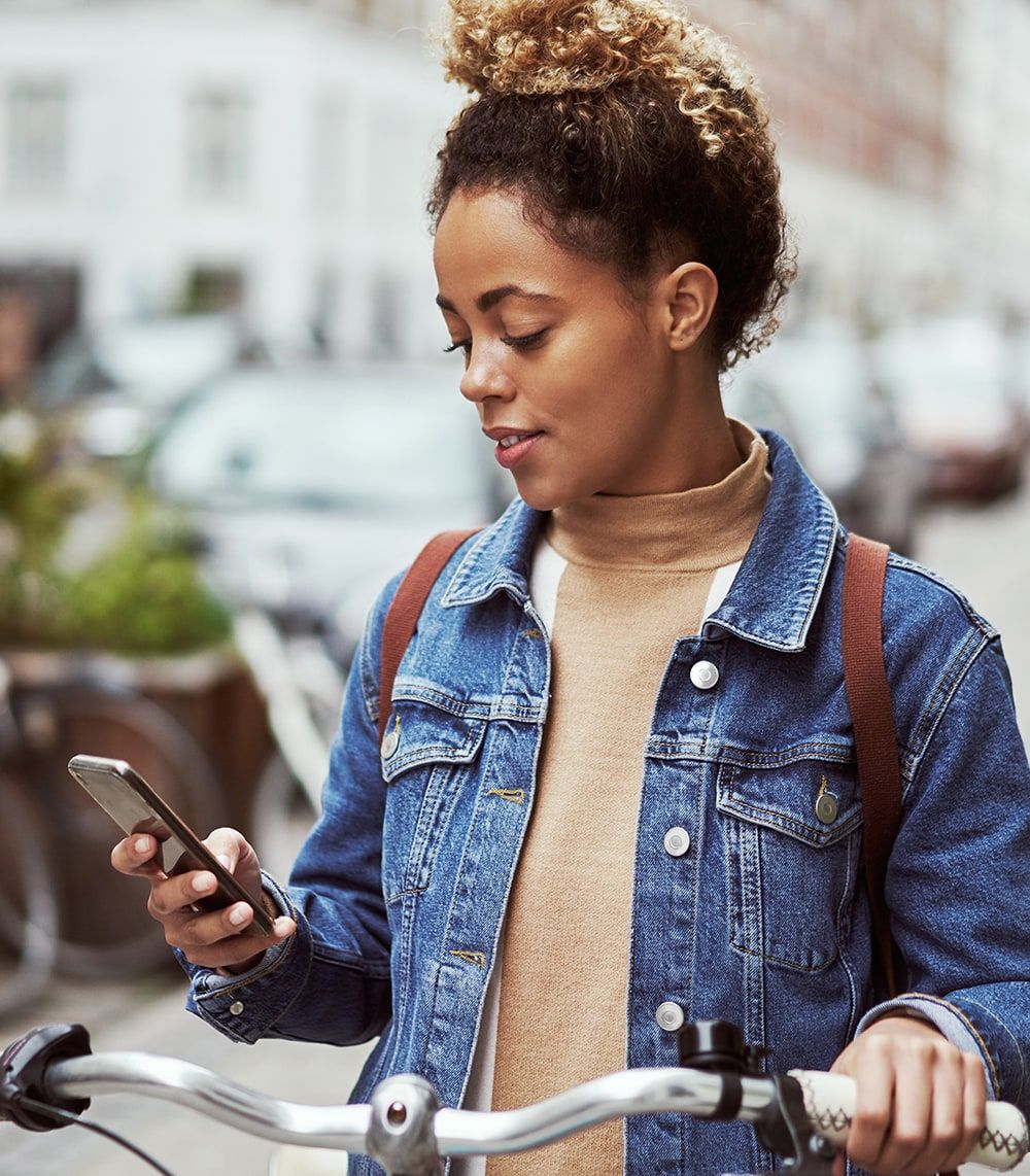 Firl looking at her phone on a bike