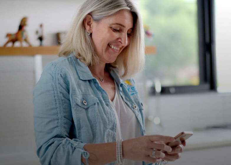 Woman doing timesheet scheduling on her cellphone from home