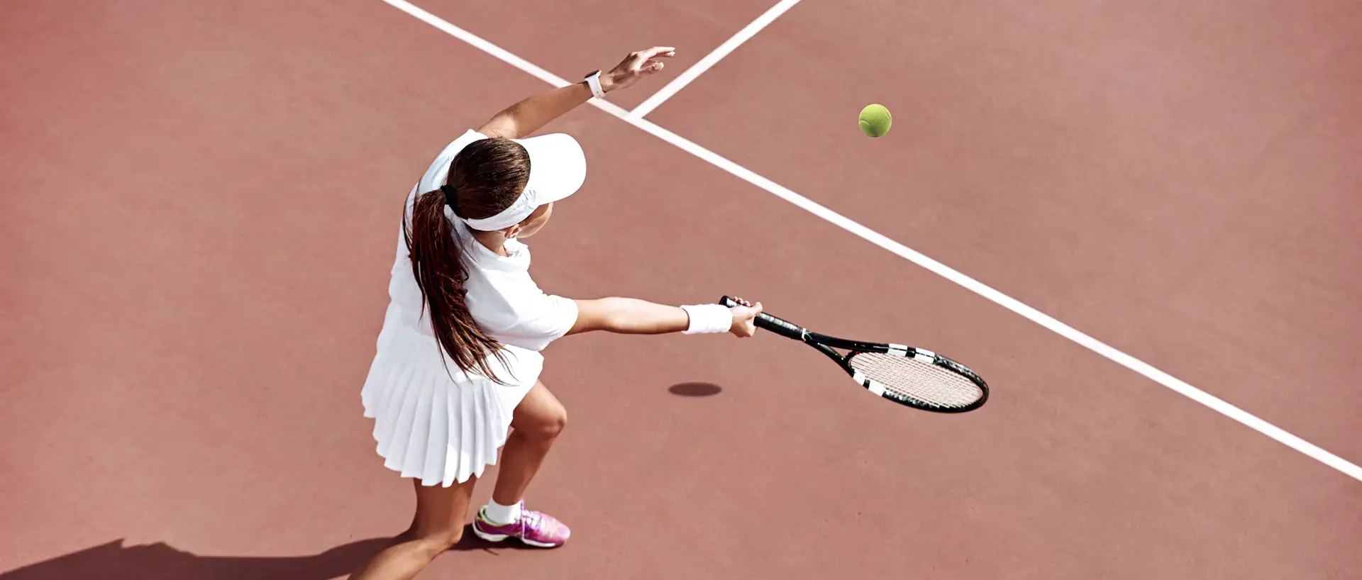 Femme vue de haut jouant au tennis.