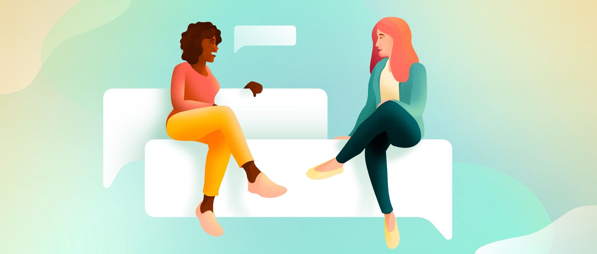 Two women talking while sitting on a speech bubble couch