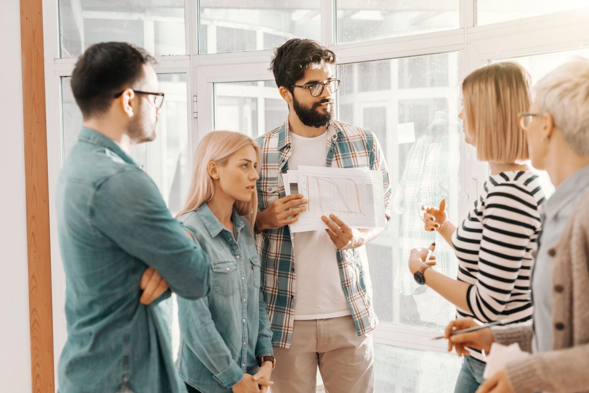 Employés faisant une rencontre debout afin de discuter de leurs tâches de la semaine