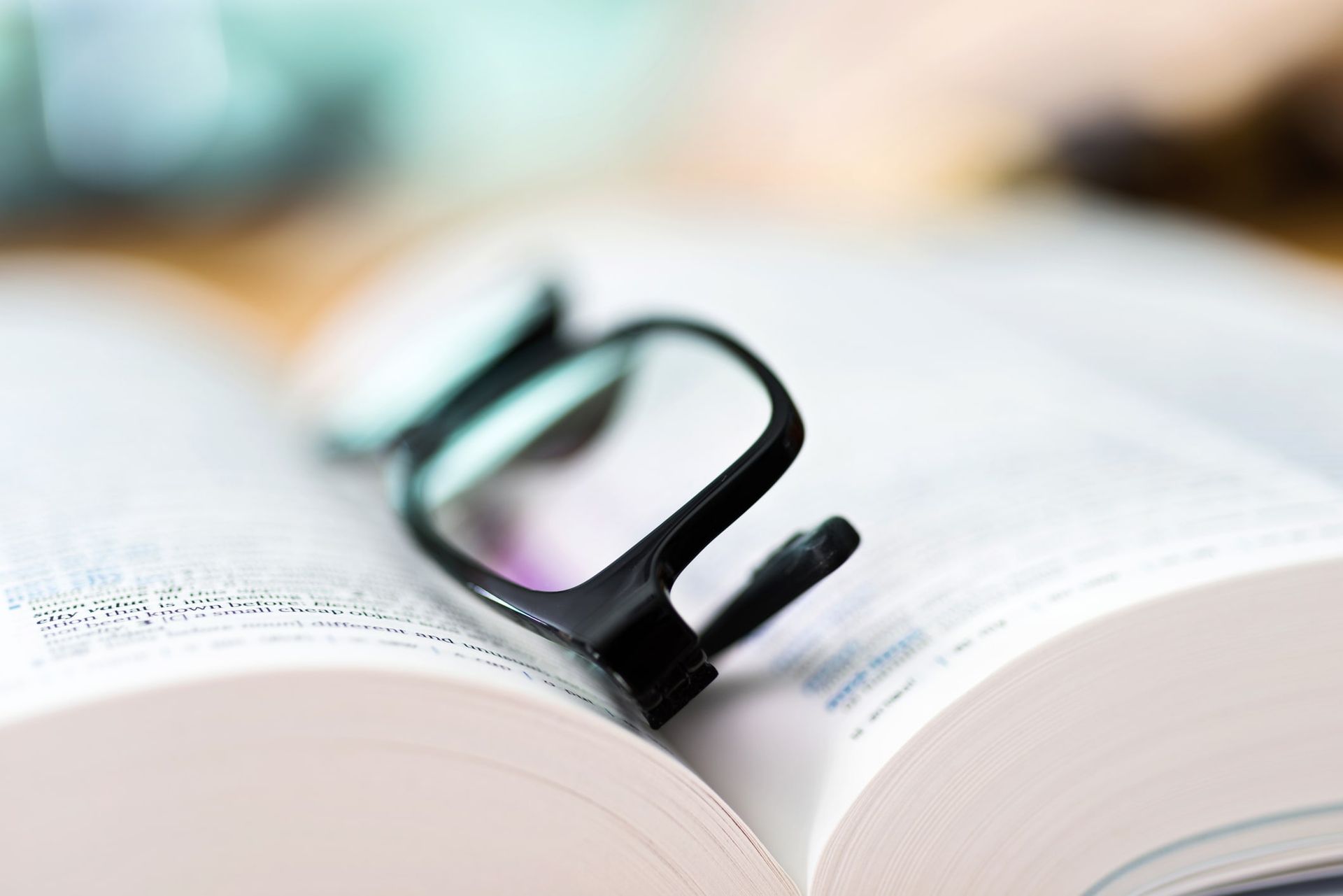 Lunette de vue noire qui repose au milieu d'un livre ouvert