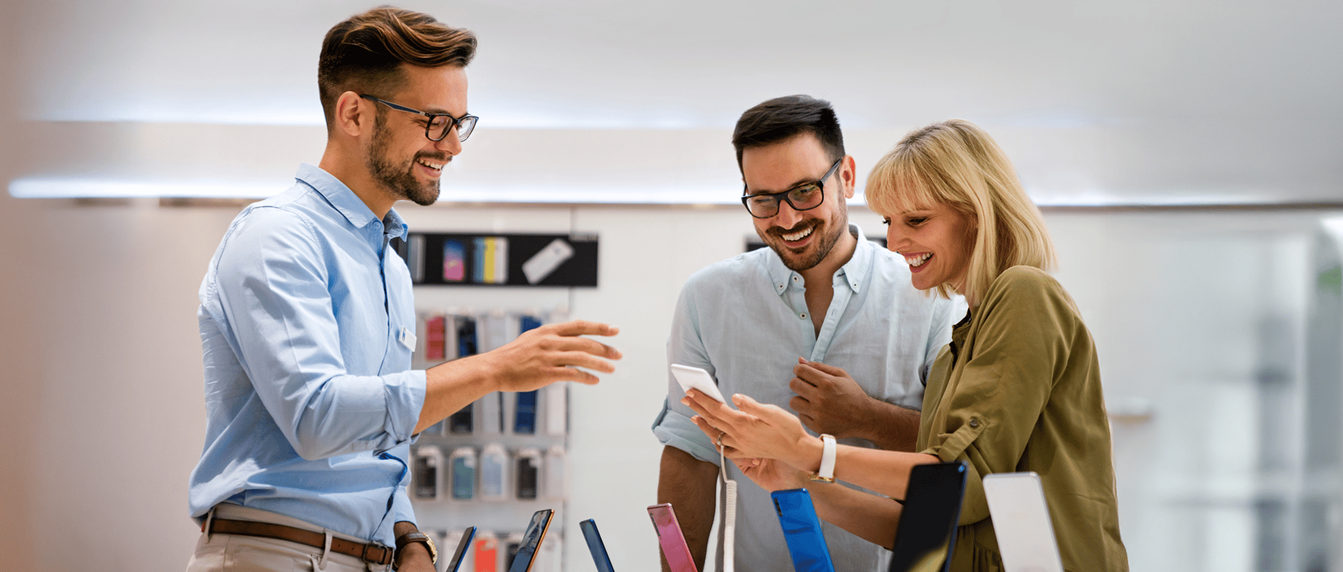 Photo of three employees looking at their phones and chatting, featured in a customer story about Bravad, an Agendrix customer.