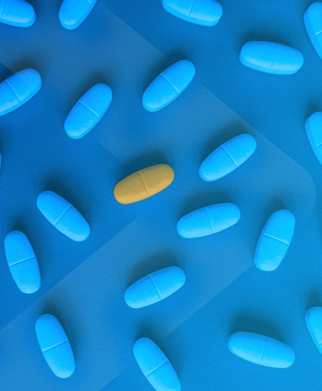 Pilule jaune singulière au milieu de plusieurs pilules bleues