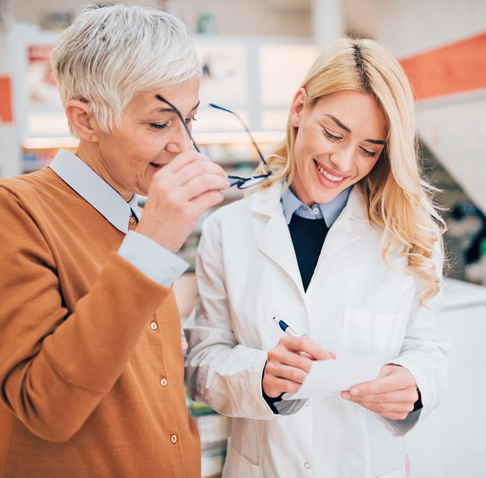 Pharmacienne et cliente discutant d'une ordonnance