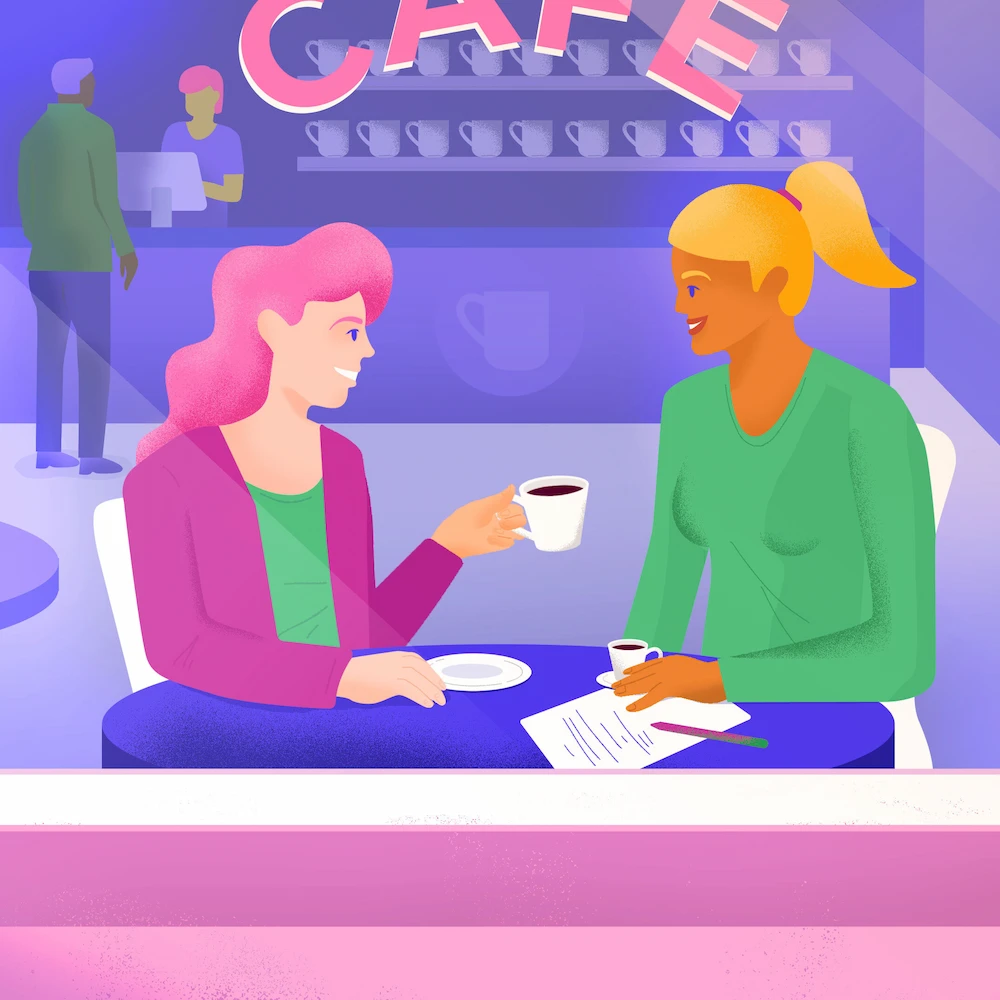 Deux femmes assises à une table, qu'on voit à travers la fenêtre d'un petit café